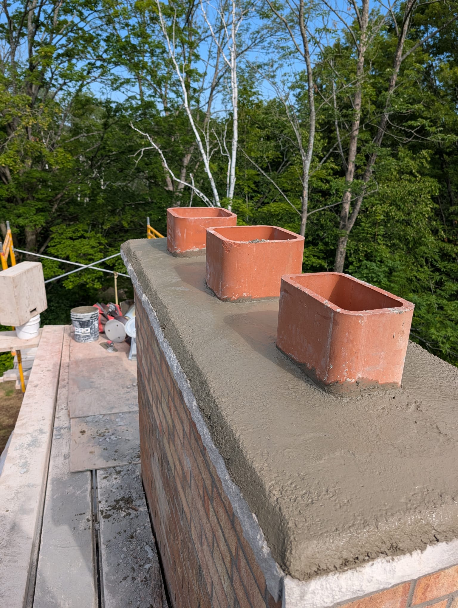Fresh concrete chimney crown with three clay flue liners