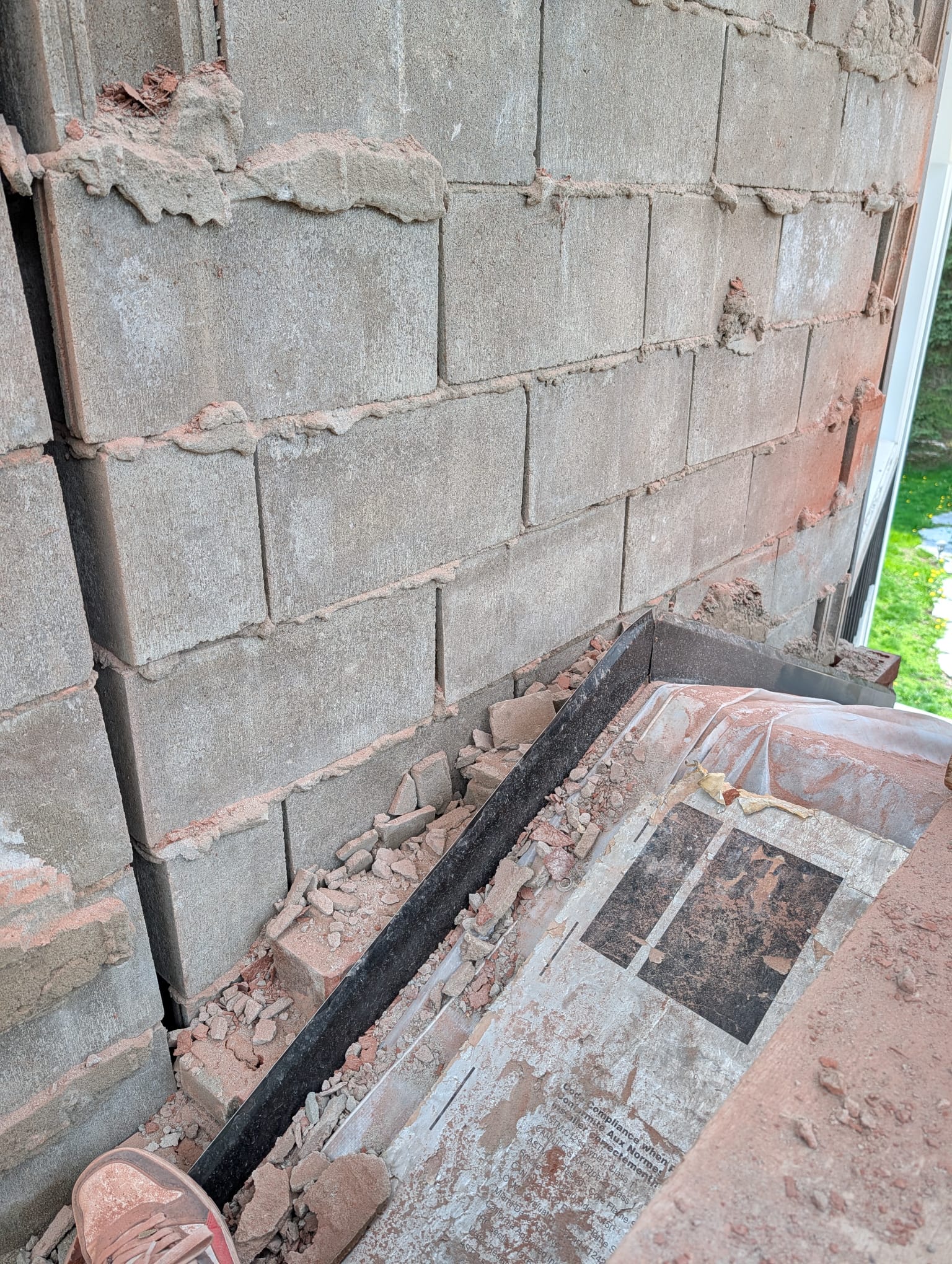 Concrete block backup wall exposed with the brick veneer removed