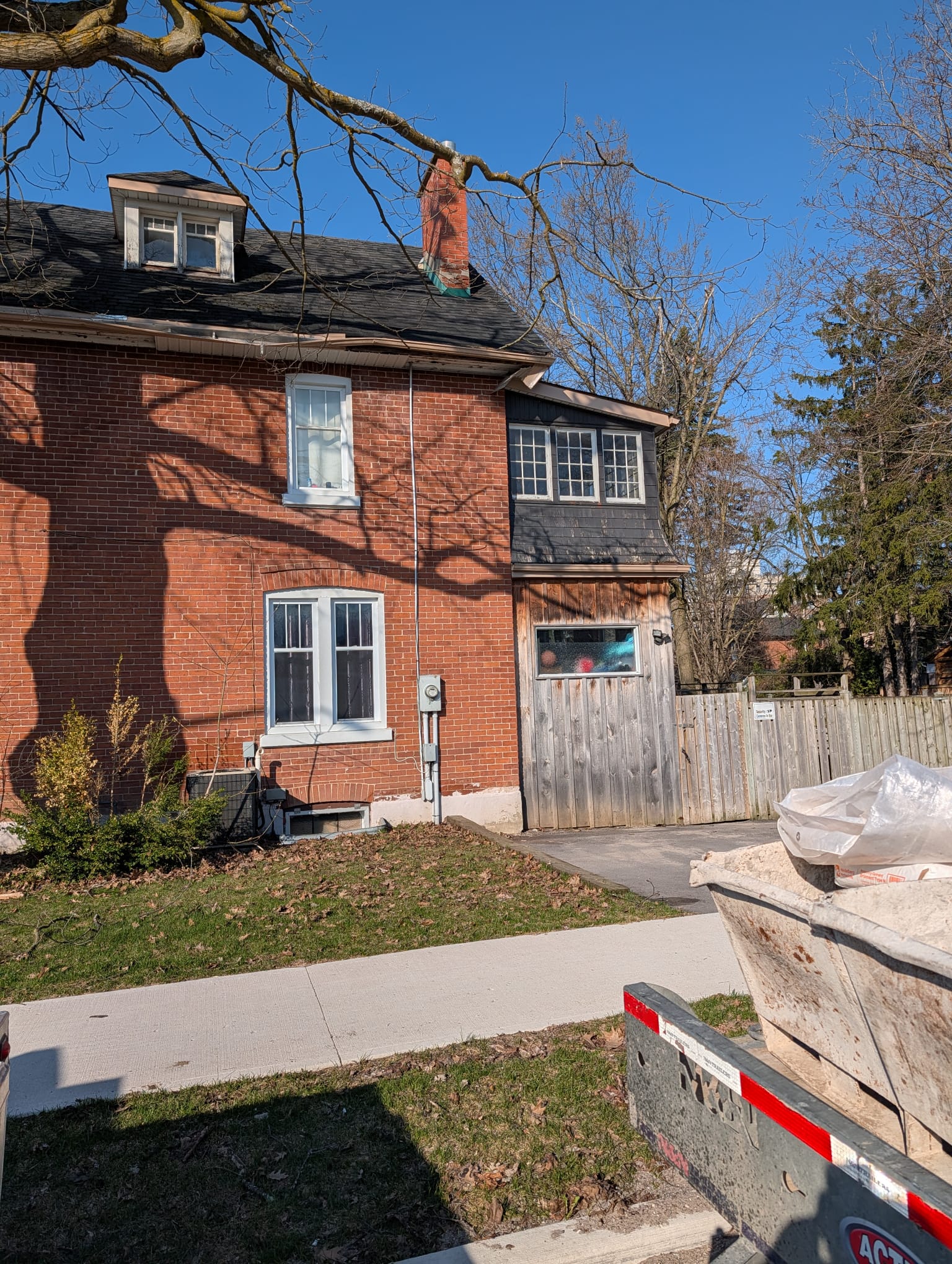 Weathered brick chimney on an older two storey red brick house