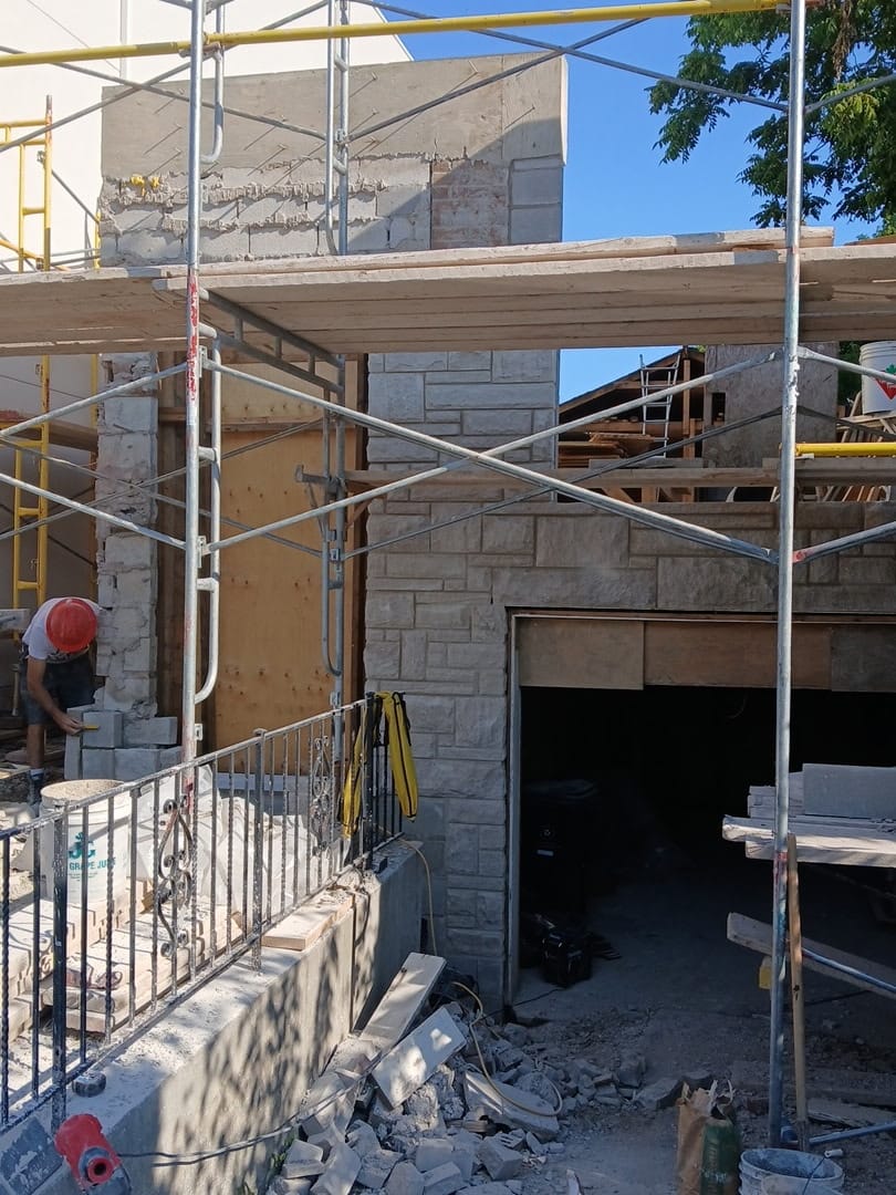 A mason laying stone veneer on a custom build