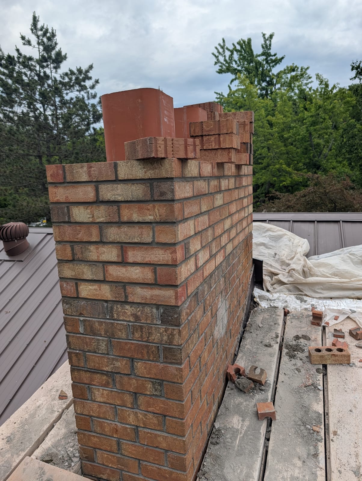 Partially built brick chimney with fresh mortar