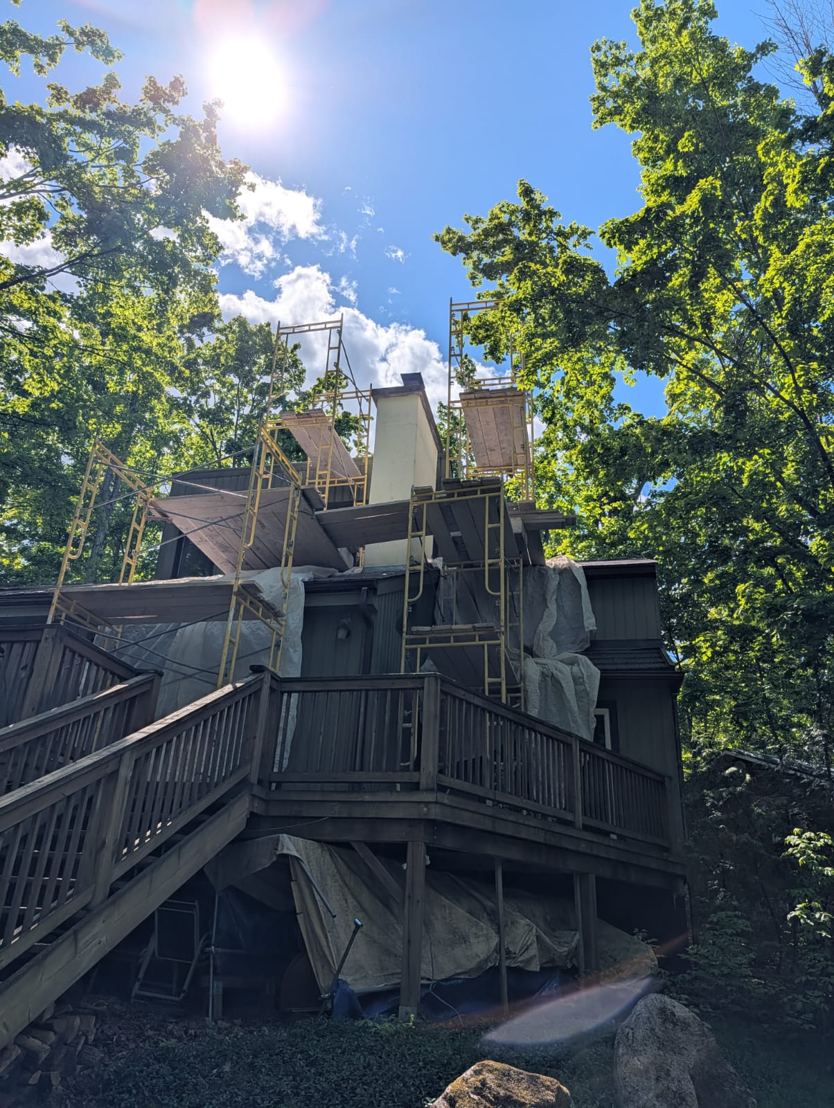 House wrapped in scaffolding and tarps during masonry work